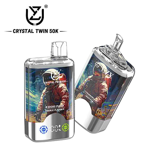 Two Metallic Crystal Twin 50K Vape Devices Featuring A Colorful Astronaut Illustration And Digital Display, With Branding And Flavor Details On The Packaging.