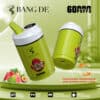 Twee Green Bang De 60000 wegwerp-vape-apparaten met een illustratie van een bebaard personage, omringd door afbeeldingen van aardbei, watermeloen, kiwi, passievrucht en guave, met opvallende kenmerken zoals drie smaken, dubbele spoel, intelligente vermogensindicator en digitale olie-indicator, en de promotie van 60.000 trekjes.