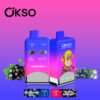 Two Okso Vape Devices With Blue And Pink Gradient Design Featuring Black Currant And Blueberry Ice Flavors, Surrounded By Images Of Black Currants, Blueberries, And Ice, With An Illustrated Monkey Character On One Device.