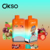 Two Okso Vaping Devices With Orange Tops And Colorful Packaging, Featuring Flavors Strawberry Cherry And Kiwi Passion Fruit Guava, Surrounded By Images Of The Corresponding Fruits On A Blue And Orange Gradient Background.