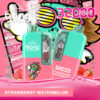 Publicité colorée pour la vape jetable Bang présentant deux appareils étiquetés « Strawberry Watermelon », des graphismes vibrants d'un personnage de dessin animé avec des lunettes de soleil, des spécifications de produit et des images de fraises et de tranches de pastèque.