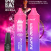 Promotie-afbeelding voor Bang Blaze Shisha met twee vape-apparaten in roze en paarse tinten met het label 'Cherry Blossom Grapes', een e-liquidfles en functies zoals '40000 pufjes', 'Type-C', '1000 mAh', '40 ml' en '0,6 Ω mesh-spoel', met een waterpijp op de achtergrond en een levendig paars-roze kleurenschema.
