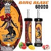 Promotie-afbeelding voor Bang Blaze Disposable Vape met een gestileerd vrouwelijk personage met rood haar en een rode cape, twee vape-apparaten met draken- en personage-thema-ontwerpen, productdetails en afbeeldingen van watermeloen, mango en perzik om de smaak aan te geven.