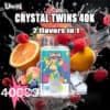 Uwin Crystal Twins 40K Vape-apparaat met een kleurrijke cartoon-aapillustratie, omringd door spetterend fruit, ijsblokjes en bessen, reclame voor 2 smaken in 1 en 40.000 trekjes. Uwin Crystal Twins 40000