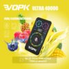Vopk Ultra 40000 Vape Device With A Digital Display, Surrounded By Splashes Of Yellow Liquid, Pineapples, Mangoes, Raspberries, And Blueberries, Highlighting Dual Flavor Switching For Blue Razz Pineapple And Triple Mango.