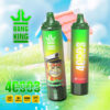Twee kleurrijke Bang King Degelbare Vape-apparaten die op gras worden weergegeven met een cartoonaap in een kapitein hoed, adverteert mango-perzik watermeloensmaak, 40.000 trekjes, type-C opladen, 1000 mAh batterij en mesh-spoel.
